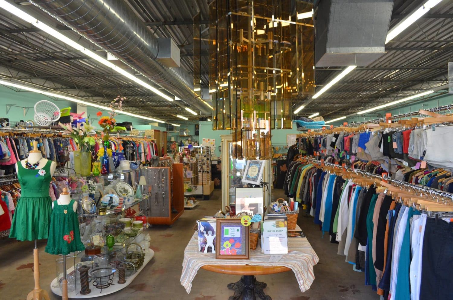 An interior photo of Family Tree Resale showing racks of clothing and tables with jewelry and home decor