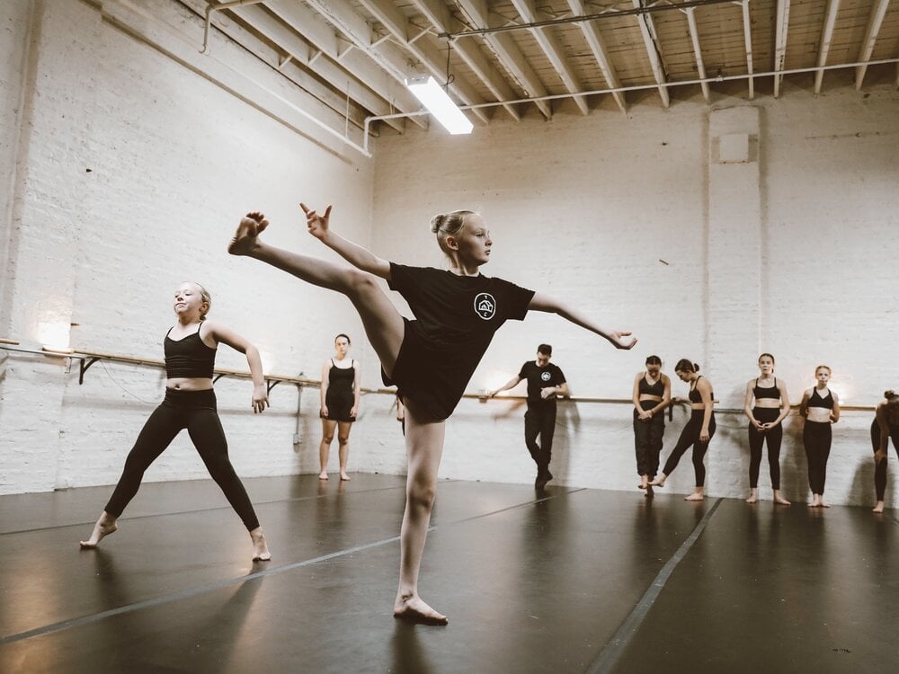 A picture of youth ballet students practicing moves in a chic industrial studio
