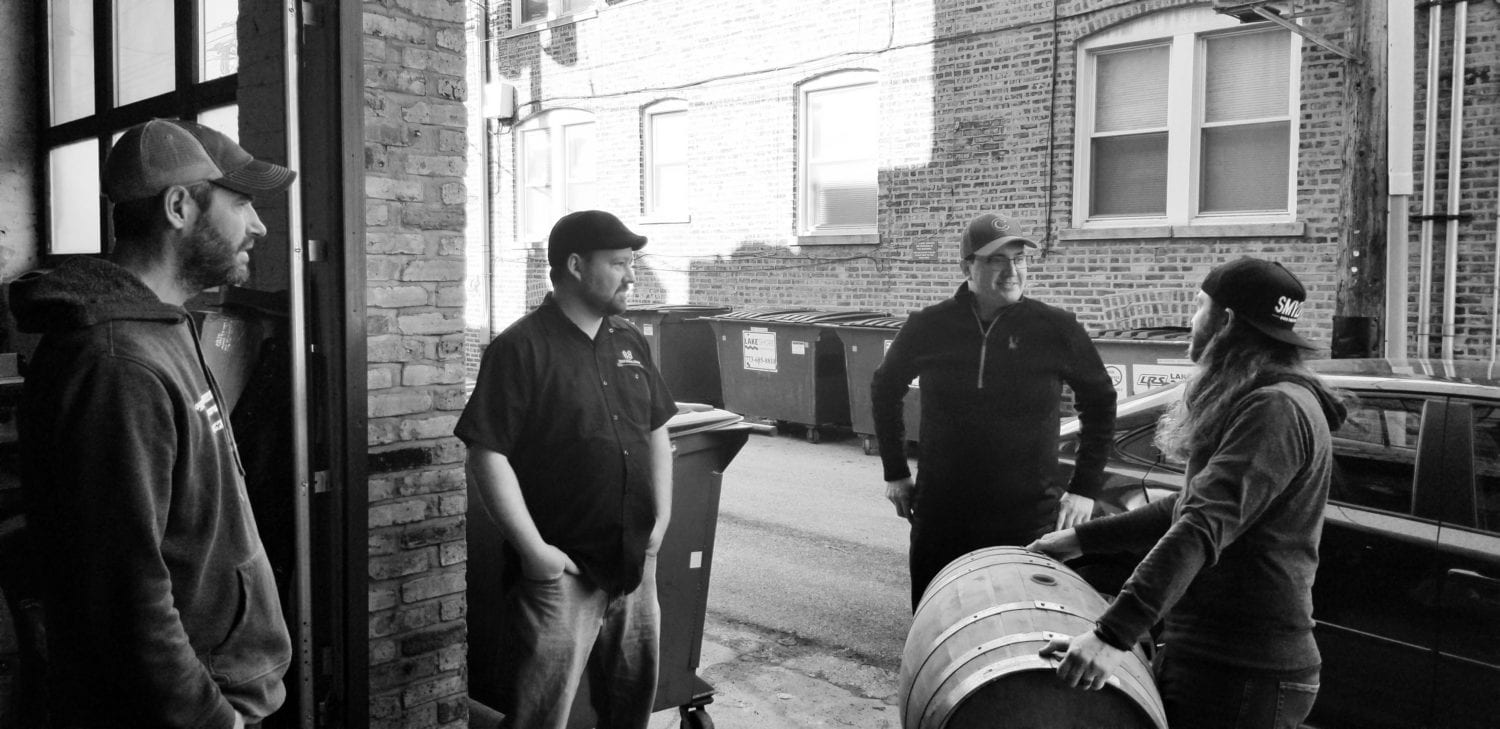 A picture of several Malt Row brewers reviewing a barrel being dropped off by KOVAL