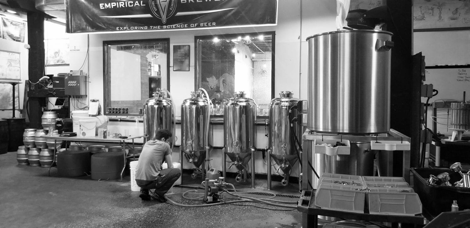 A picture of Empirical's Jacob Huston monitoring brewing equipment