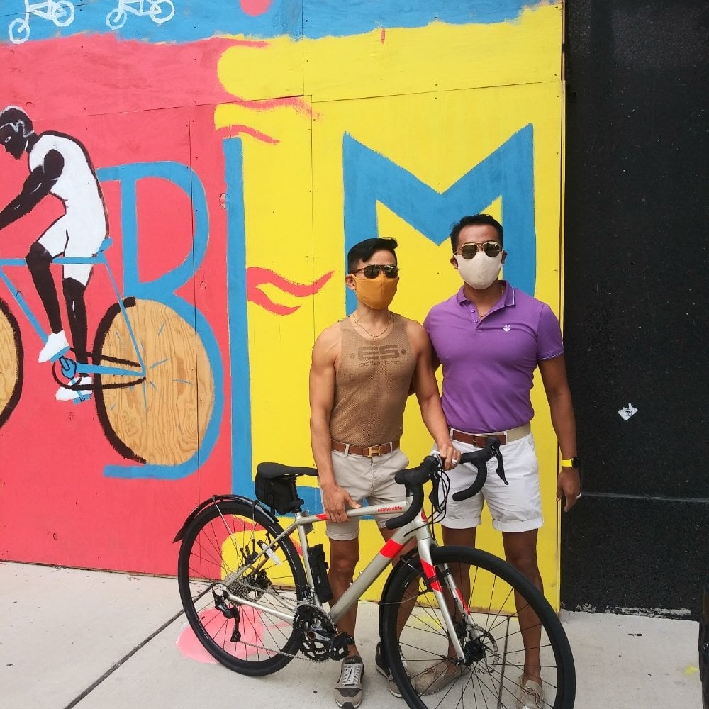 Customers pose with their new bike in front of the BLM mural at On the Route Bicycles