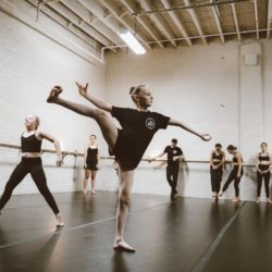 A picture of youth ballet students practicing moves in a chic industrial studio