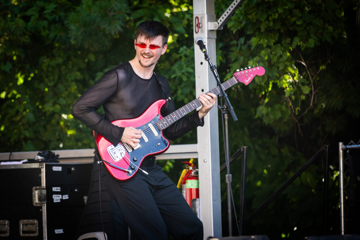 A musician playing guitar while on stage at Ravenswood On Tap