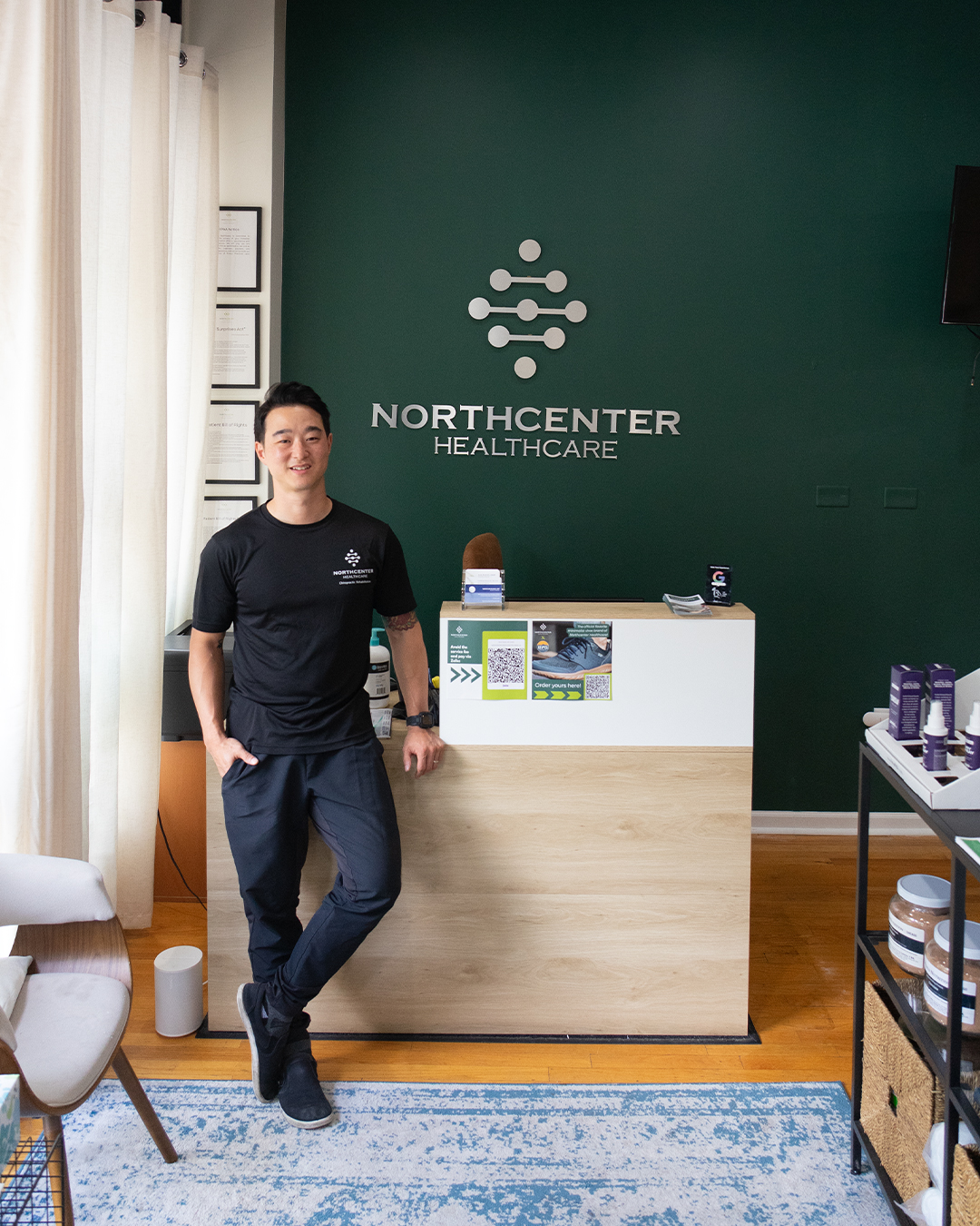 Dr. Andy Park leans against a desk in Northcenter Healthcare