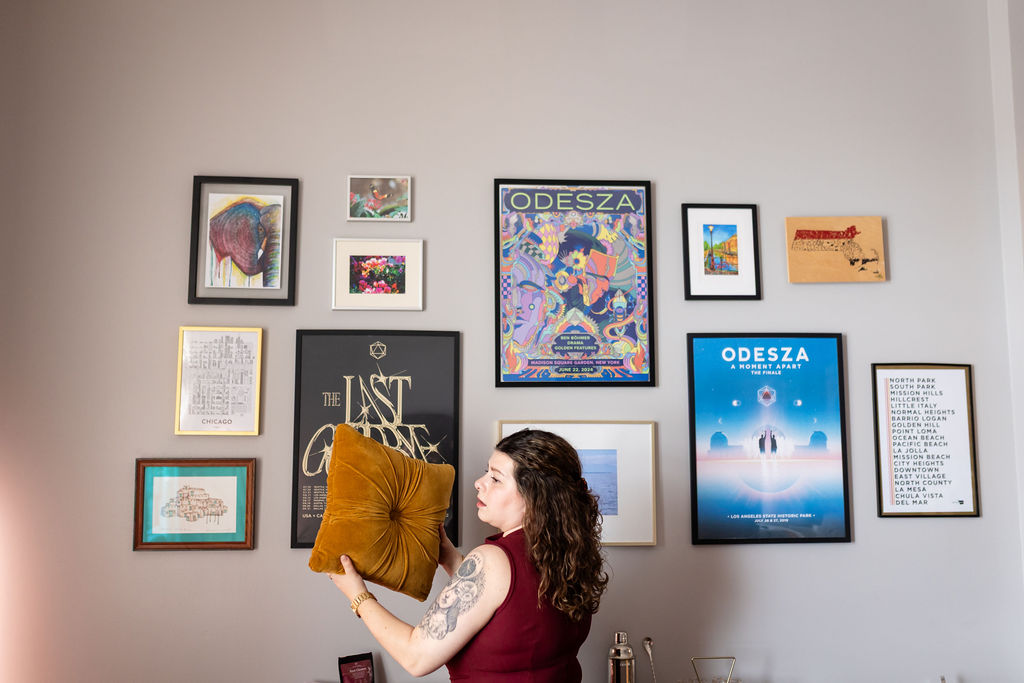 Lindsay stands in front of several framed posters on the wall
